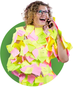 A bespectacled woman covered in post-it notes while talking on the phone.